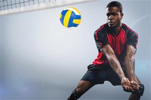 Young man positioning to hit a brightly colored volleyball